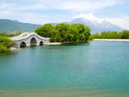 Qingxi reservoir and beautiful bridge with Jade Dragon Snow Mountainの写真素材