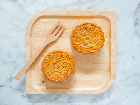 Mooncakes on a wooden plate for Mid-Autumn Festival or Mooncake Festival. Top view.の写真素材