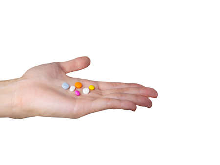 Hand holding colorful medicines and pills isolated on white backgroundの写真素材