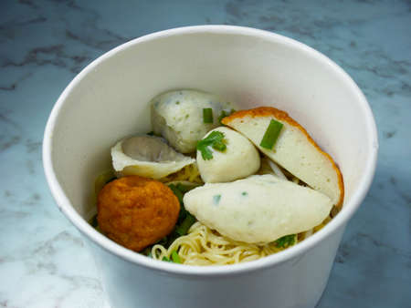 Egg noodle with many kinds of fish balls in takeaway box