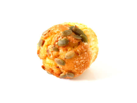 Pumpkin muffin topped with pumpkin seeds isolated on white backgroundの写真素材