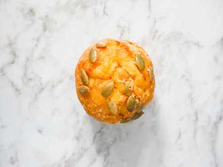 Pumpkin muffin topped with pumpkin seeds on the tableの写真素材