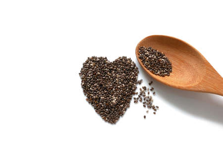 Heart shaped chia seeds and wooden spoon isolated on white backgroundの写真素材