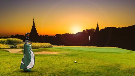 golf equipment on green and hole as background.の写真素材