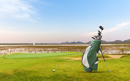 golf equipment on green and hole as background.の写真素材