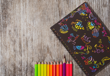Colourful Ideas design notepad,Colourful icons design book and pencil color on wooden  blackground with space for text .の写真素材