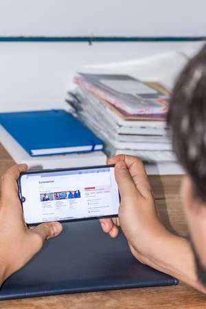 guy checking news about coronavirus on his celphoneのeditorial素材