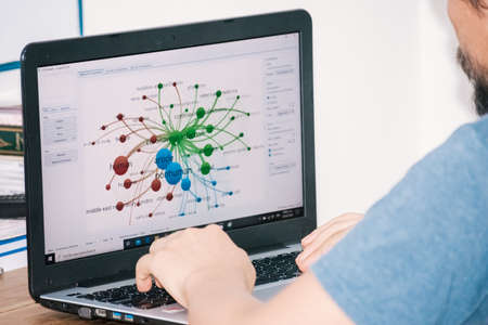 a guy checking a graphic about the coronavirus on his computerのeditorial素材