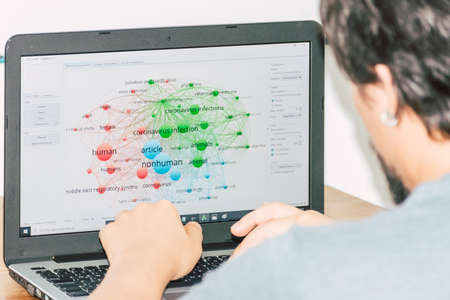 a guy checking a graphic about the coronavirus on his computerのeditorial素材