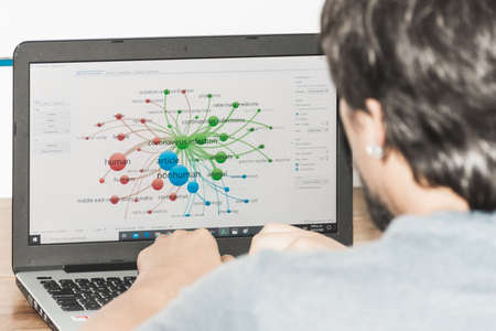 a guy checking a graphic about the coronavirus on his computerのeditorial素材