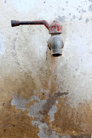 Old rusted tap on wallの写真素材