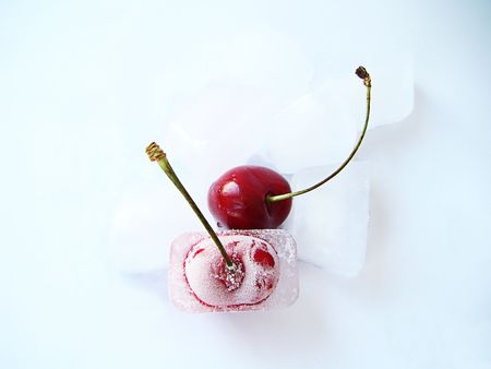 Two sweet cherries, one in ice, not a white background                                 の写真素材