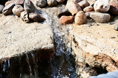 Cascade falls over old plum river with rocks の写真素材