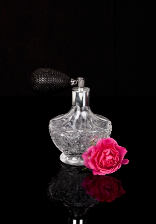 Luxurious perfume bottle atomizer with flower blossom isolated on black background. の写真素材