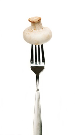 fresh champignon mushroom on fork, isolated on a white background の写真素材