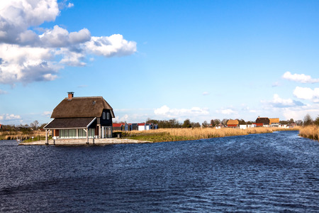 Landscape with houses on coast of a pondの写真素材