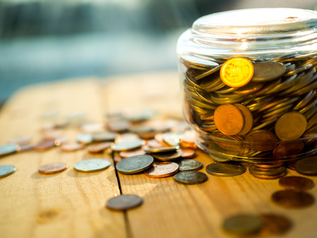 Upside down the jar of coins on the wooden background, bankruptcy or loss concept