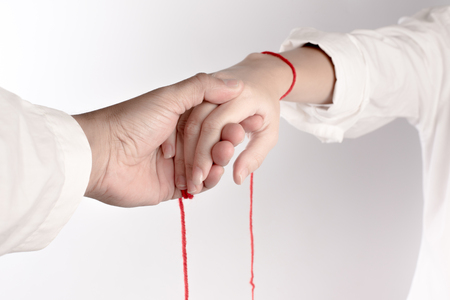 A hand of couple touch each other. The Faith of red thread brings destiny.の写真素材