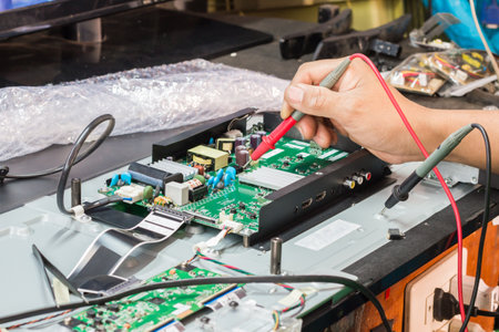disassembly and repair of  lcd tv  by engineer or technician in shop, selective focus.