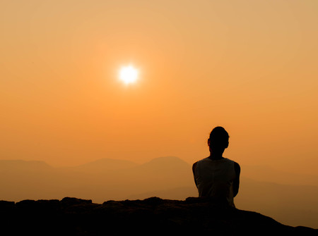 woman is looking beautiful sunrise with mountain viewの写真素材