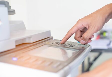 Man is pressing the button of printer