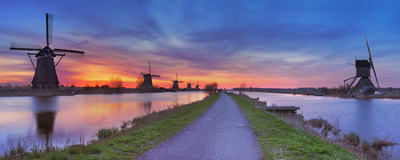 Traditional Dutch windmills with a colourful sky just before sunrise. Photographed at the famous Kinderdijk.の写真素材