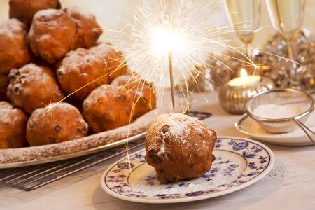 'Oliebollen', traditional Dutch pastry for New Year's Eve. With champagne and sparklers in the background.の写真素材