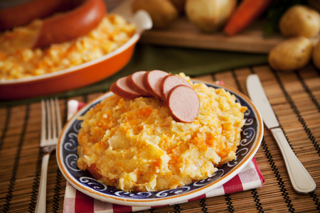 'Hutspot met worst' - a traditional Dutch dish with mashed potatoes, carrots, onions and smoked sausage.の写真素材