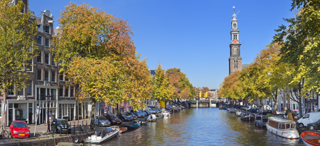 A canal with the Westerkerk tower in the city of Amsterdam, The Netherlands. Photographed on a beautiful day in early autumn.の写真素材