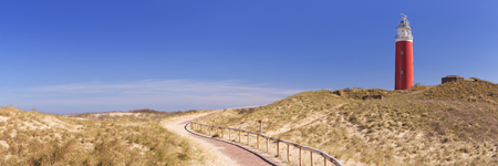 A footpath leading towards the lighthouse of the island of Texel in The Netherlands on a sunny day.の写真素材