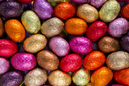 Assortment of red, yellow and pink chocolate Easter eggs.