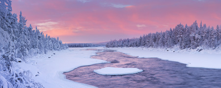 A rapid in a river in a wintry landscape. Photographed at the ijkoski rapids in the river in Finnish Lapland Muonionjoki at sunrise.の写真素材