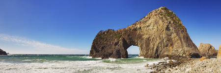The natural arch Senganmon on the rocky coastline of the Izu Peninsula in Japan on a beautiful...