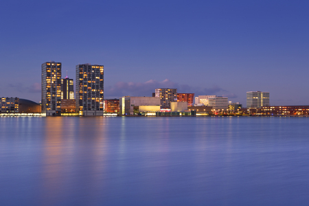 The skyline of the city of Almere in The Netherlands, photographed from across the water at dusk.の写真素材