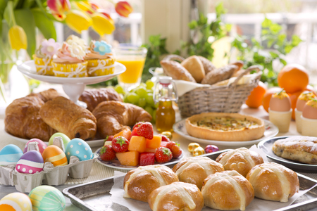Breakfast or brunch table filled with all sorts of delicious delicatessen ready for an Easter meal.の写真素材