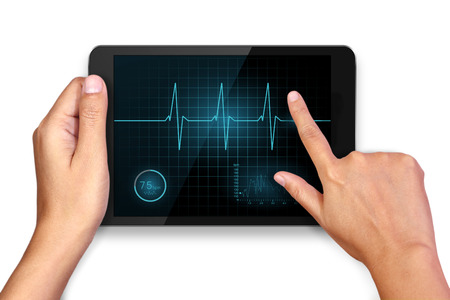 Hands holding and heart cardiogram sign on tabletの写真素材