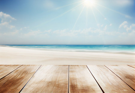Wooden table against view of sandy beach under blue sky with cloudsの素材