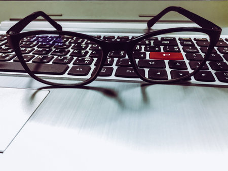 Businessman's glasses on laptop keyboard, Office life