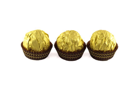 Chocolate balls wraped in the golden package isolated on whiteの写真素材