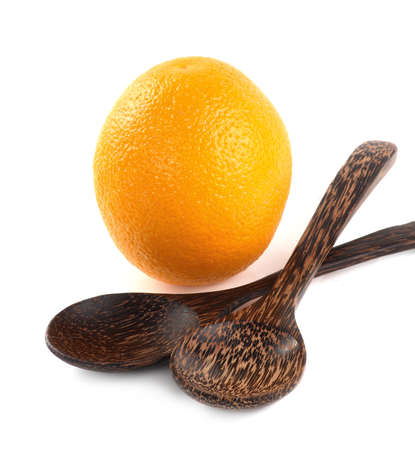 Orange fruit and wooden spoon isolated on white background.の写真素材