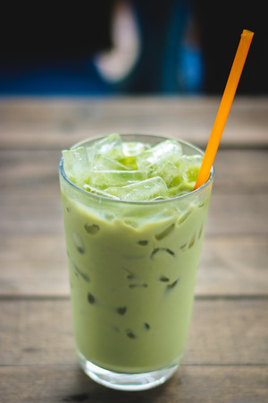 Ice green tea in glass on wood table.