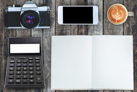 Coffee,notebook,mobile phone,calculator and camera on old wood texture background.の写真素材