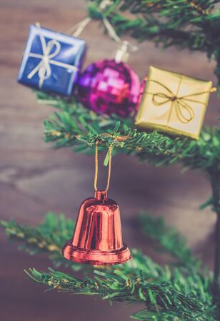 Christmas gift ornaments hang on Christmas Tree have space wood background.の写真素材