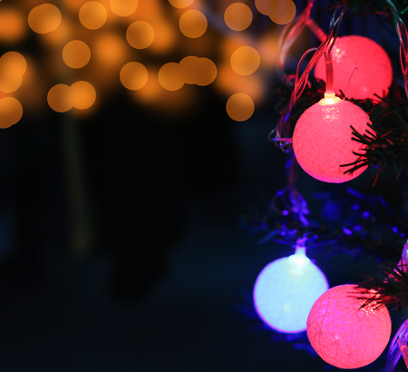 Christmas light ornaments hang on Christmas tree with bokeh.の写真素材