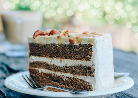 Coffee cake with almond on white plate in coffee shop.の写真素材