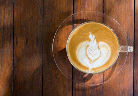 Top view coffee latte art on wood table.の写真素材