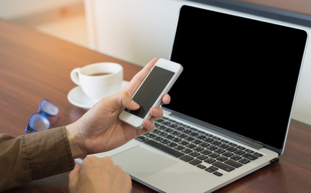 businessman using cell phone with laptop working in office vintage tone.の写真素材