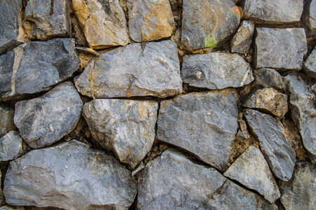 Walls built with old stone house in the background.