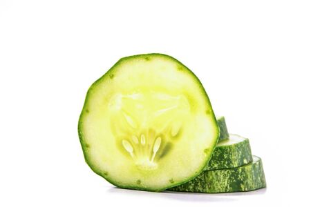 Cucumber, cut into pieces stacked on white background.の写真素材