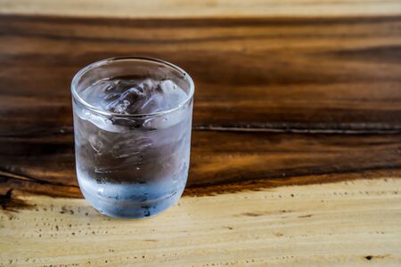 Put a glass of water placed on a wooden table on the left.の写真素材